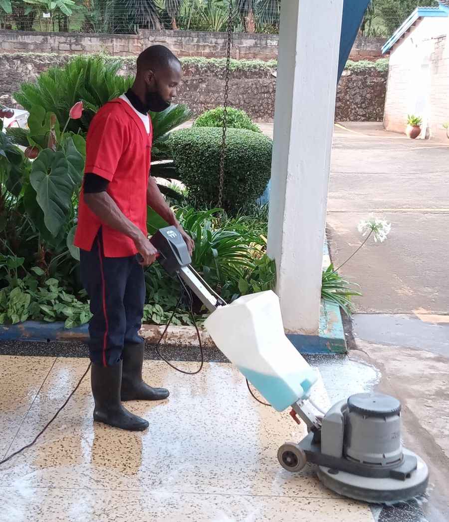 Steps Ahead team member operating a floor buffer machine outdoors