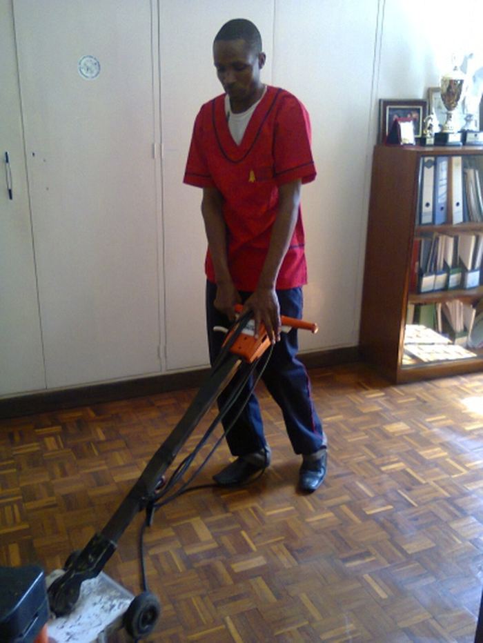 Cleaner mopping a corridor floor