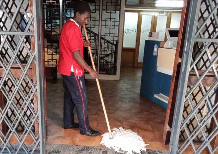Cleaner cleaning an office kitchen refrigerator area
