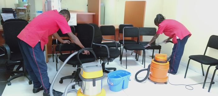 Team member operating a floor scrubber machine on an outdoor walkway