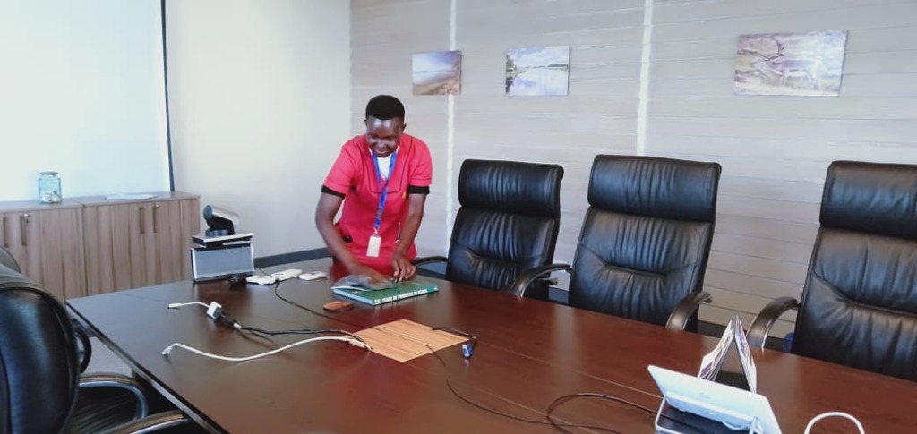 Team member wiping down a boardroom conference table