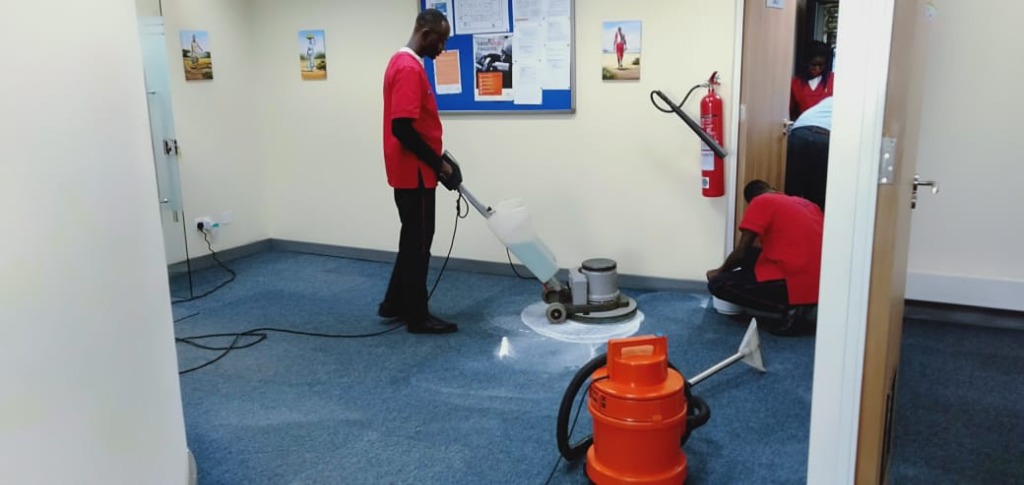 Team polishing a blue office carpet with floor machine